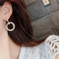 Gold-tone round hoop crystal earrings on model, side view