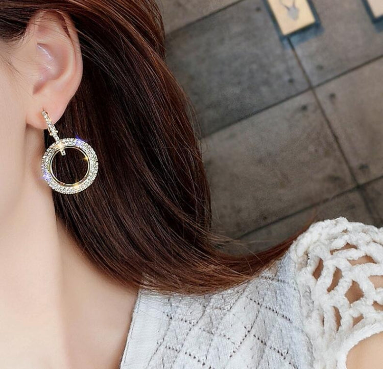 Gold-tone round hoop crystal earrings on model, side view