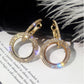 Gold-tone round rhinestone hoop earrings with circular center ring