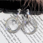 Silver-tone round rhinestone hoop earrings with dangling circle charm, pair close-up