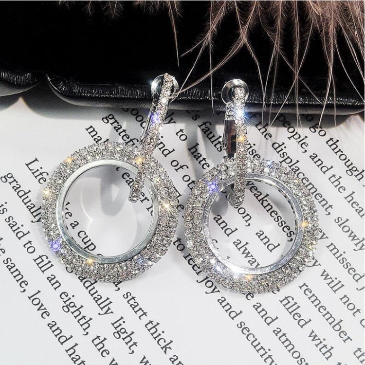 Silver-tone round rhinestone hoop earrings with dangling circle charm, pair close-up