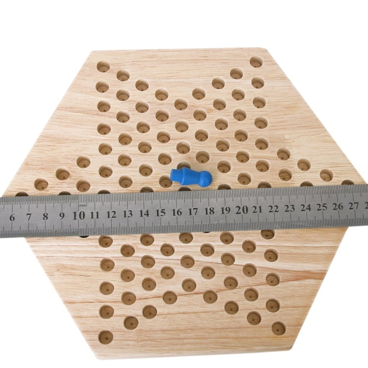 Hexagon wooden checkers board with circular holes and ruler for size comparison