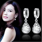 Sterling silver hoop drop earrings with ornate teardrop dangle pendant.
