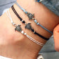 Set of sea turtle wax-string anklets on ankle, with bead and shell charms
