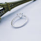 Silver-tone heart wedding ring, front view on a flat surface