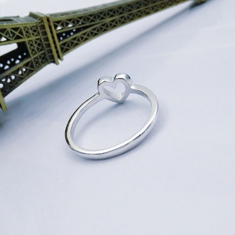 Silver-tone heart wedding ring, front view on a flat surface