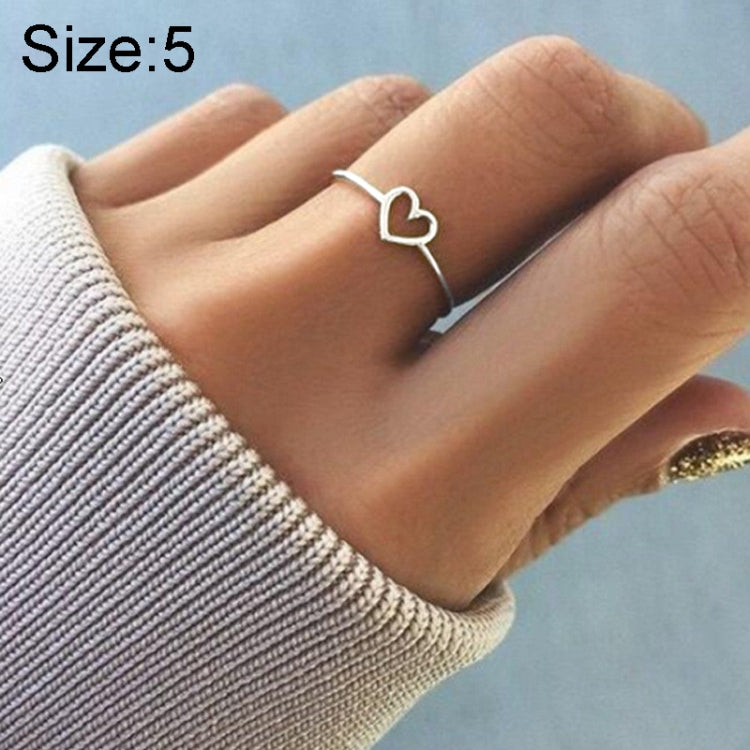 Rose gold-tone heart wedding ring on finger, Size 5