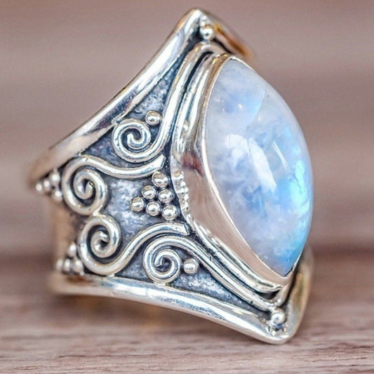 Silver ring with ornate filigree and large oval light-blue gemstone