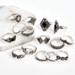 Silver-tone decorative ring set with floral and lotus motifs and black gemstone details