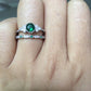 Two-piece zircon gemstone ring set with green stones, stacked on a finger