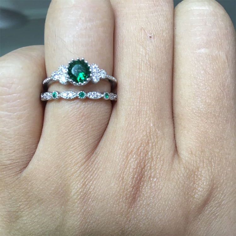 Two-piece zircon gemstone ring set with green stones, stacked on a finger