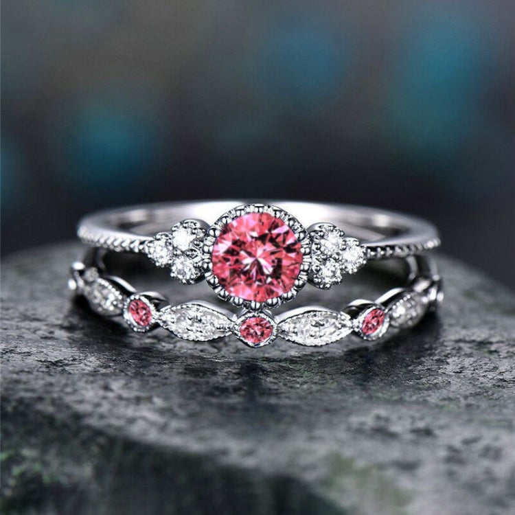 Double zircon ring set in silver tone with pink round centerpiece and small clear stones.