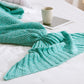 Knitted mermaid tail blanket in teal, folded fin and gathered tail knot