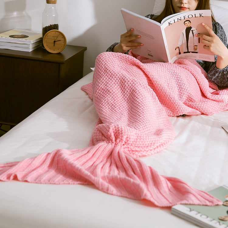 Knitted mermaid tail blanket in pink, draped with fin tail and twisted knot