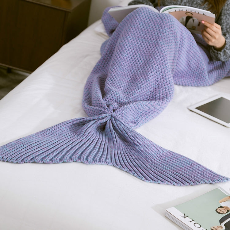 Knitted mermaid tail blanket in light purple, fin tail spread on bed