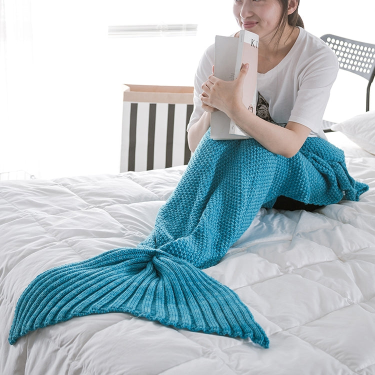 Knitted mermaid tail blanket in turquoise, wrapped around body like a tail