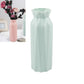 Light green plastic round vase with faceted sides and flared rim, tall cylinder shape