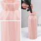 Pink plastic round vase with faceted sides and wide flared opening