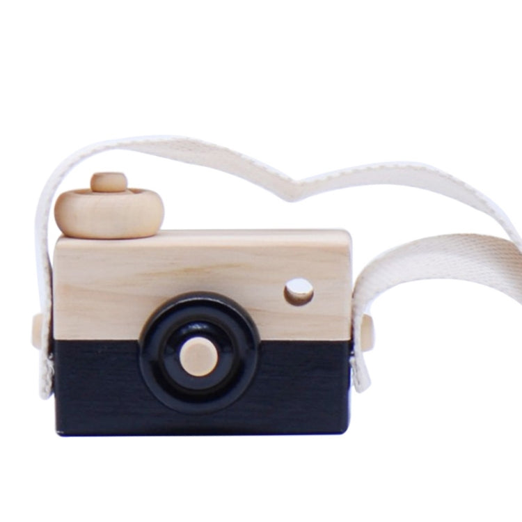 Children's wooden camera toy with dark blue body, round lens, and fabric strap