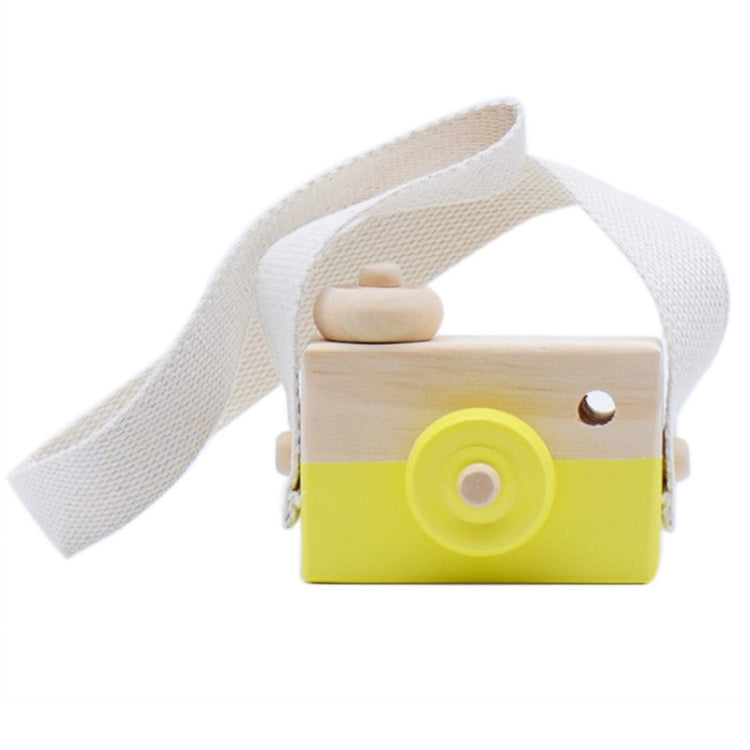 Children's wooden camera toy with yellow body, round lens, and cloth carrying strap