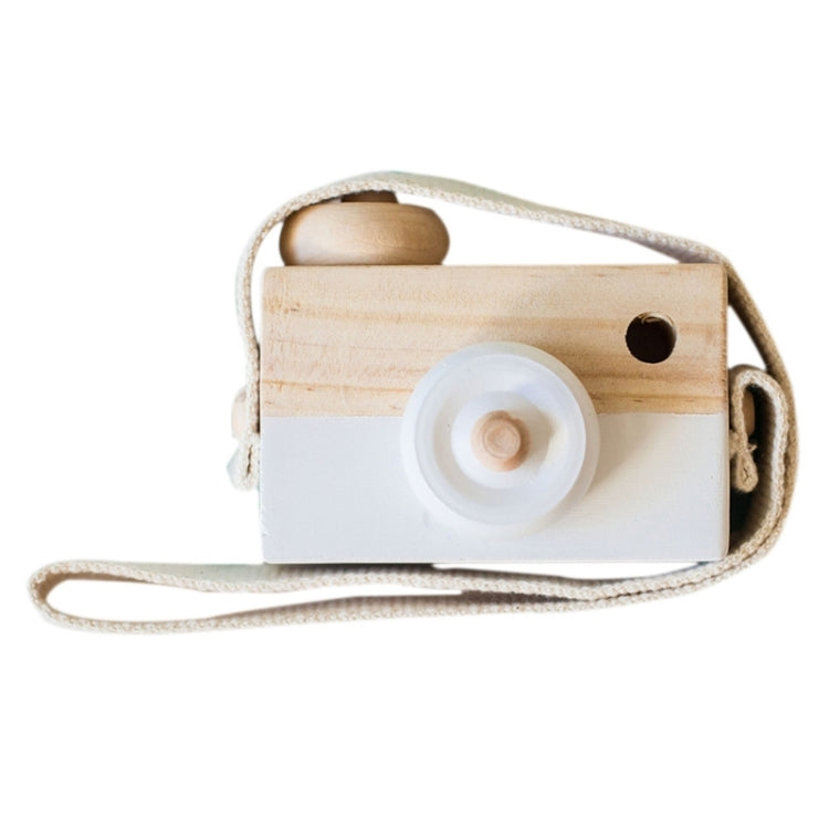 Children's wooden camera toy with white body, round lens, and fabric strap