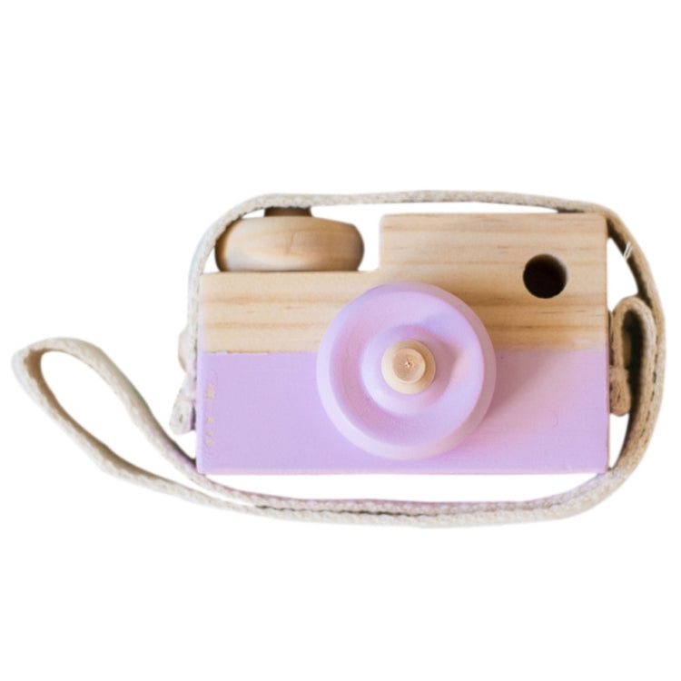 Children's wooden camera toy with purple body, round lens, and cloth strap