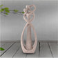 Sandstone cameo statue featuring heart arms and a looping oval center, textured beige.