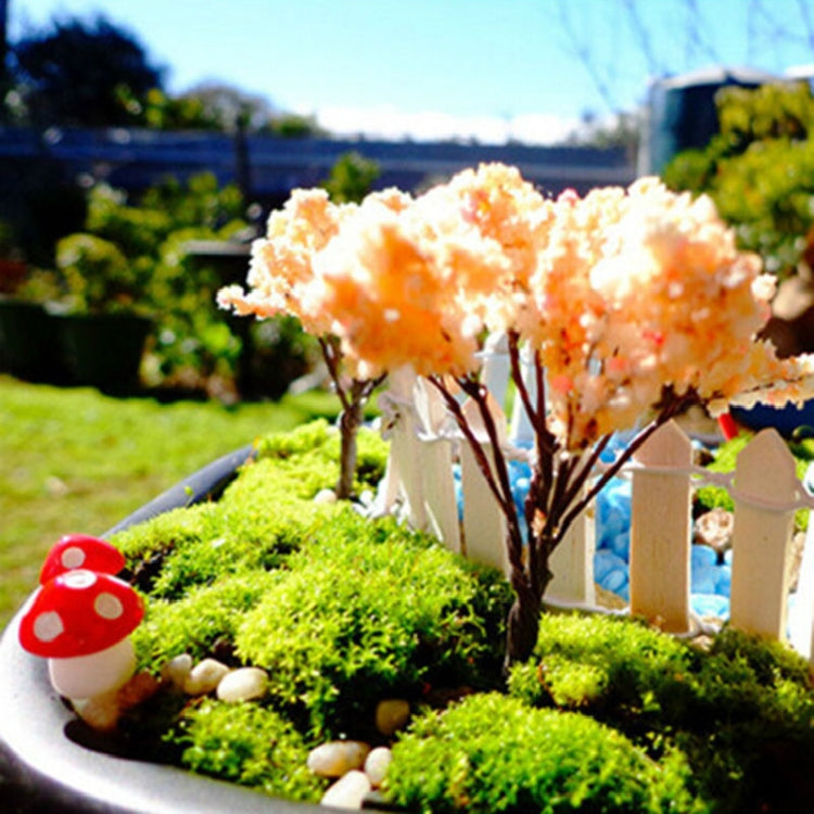 Mini foam mushroom decoration with red cap and white spots in a garden scene