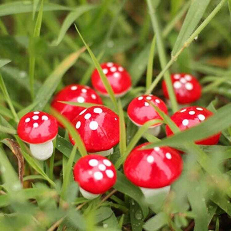 Close-up mini foam mushrooms in grass: red caps with white spots, white stems