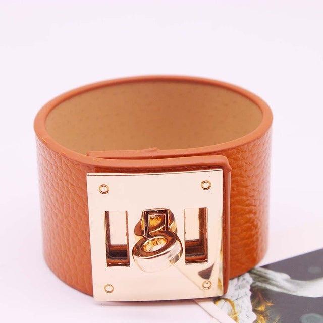 Wide leather cuff bracelet in orange-brown with gold-tone square logo plate and rivets