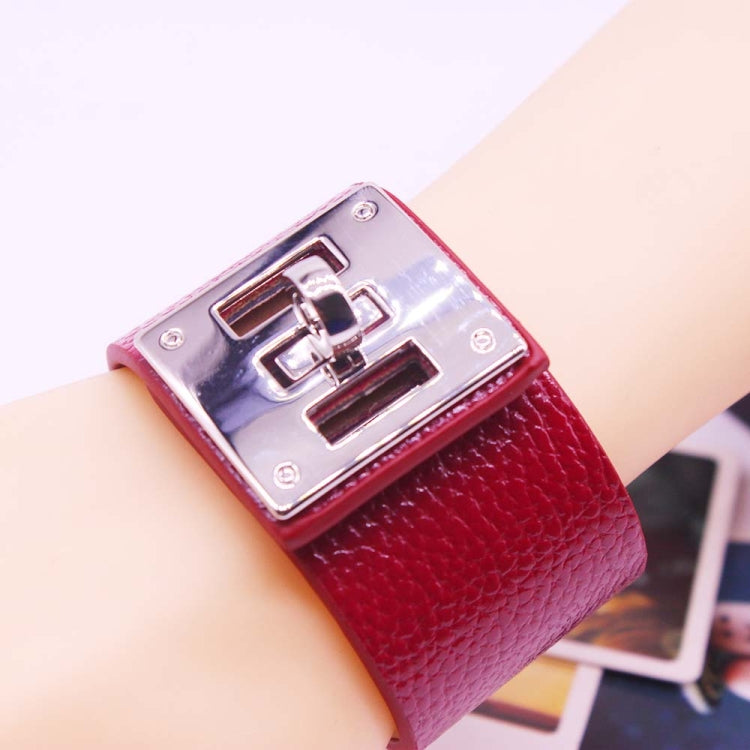 Wide red leather cuff bracelet with silver-tone square logo plate and shiny metal clasp