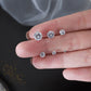 Round zircon stud earrings trio in hand, large center stone with two smaller studs