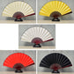 Blank silk folding fans shown in multiple colors, including beige, white, yellow, and black on stands.