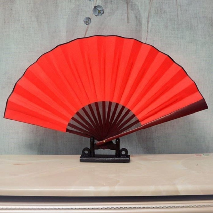 Red blank silk folding fan with maroon inner ribs, Chinese-style, on black stand