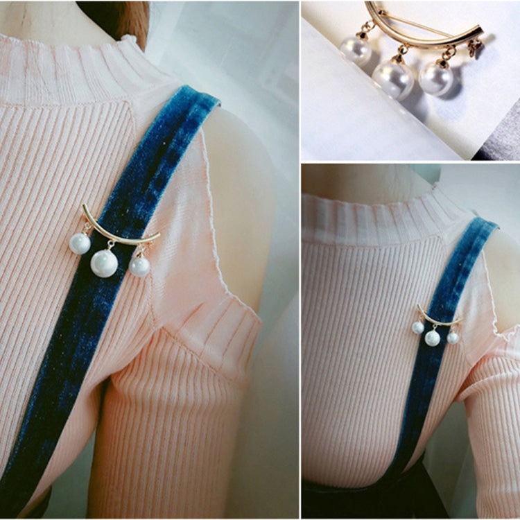 Pearl drop brooch on knit cardigan sleeve, gold-tone curved bar with three white pearls