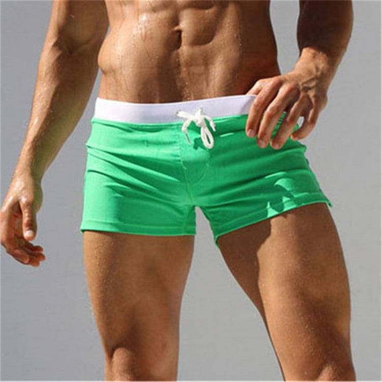 Men's green swim shorts with white trim waistband and tied drawstring front