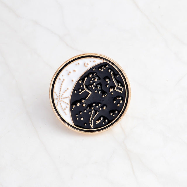 Gold-rimmed enamel moon constellation brooch pin, dark blue night sky design.