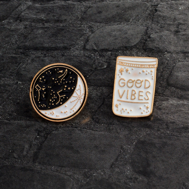 Set of enamel brooch pins: round moon constellation pin and “Good Vibes” bottle pin.