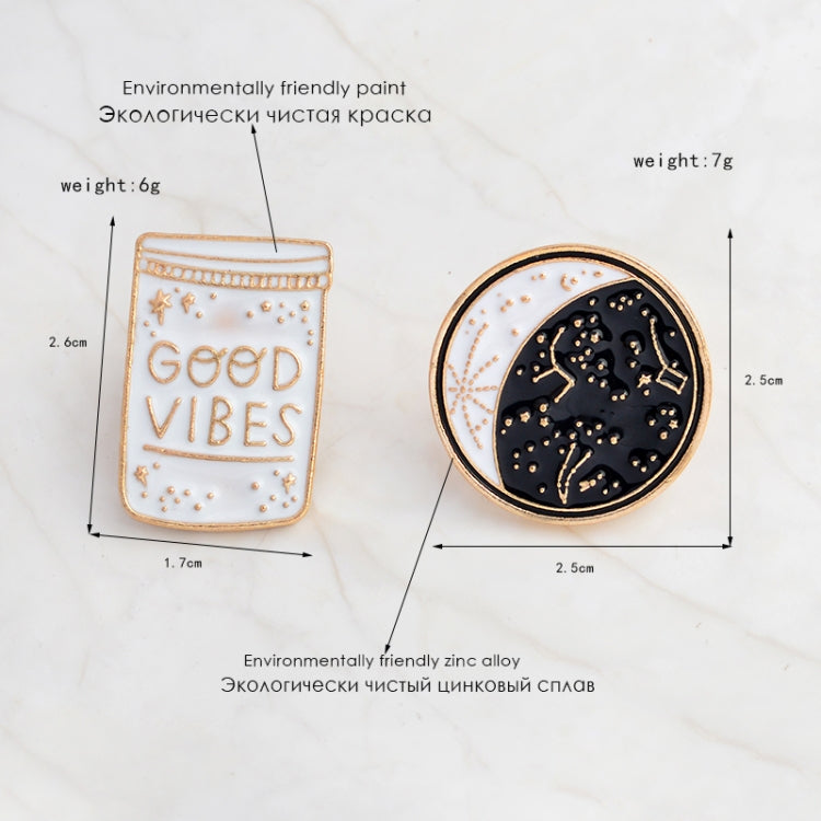 Two enamel brooch pins: “Good Vibes” bottle and gold-rimmed moon constellation pin.