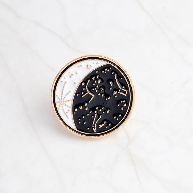 Round enamel moon constellation pin with gold border, dark blue sky and stars.