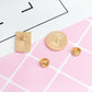 Gold-tone brooch pins with sunburst circle and square shapes, and pin backs.