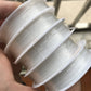 Handheld stack of transparent fishing line spools for DIY beading