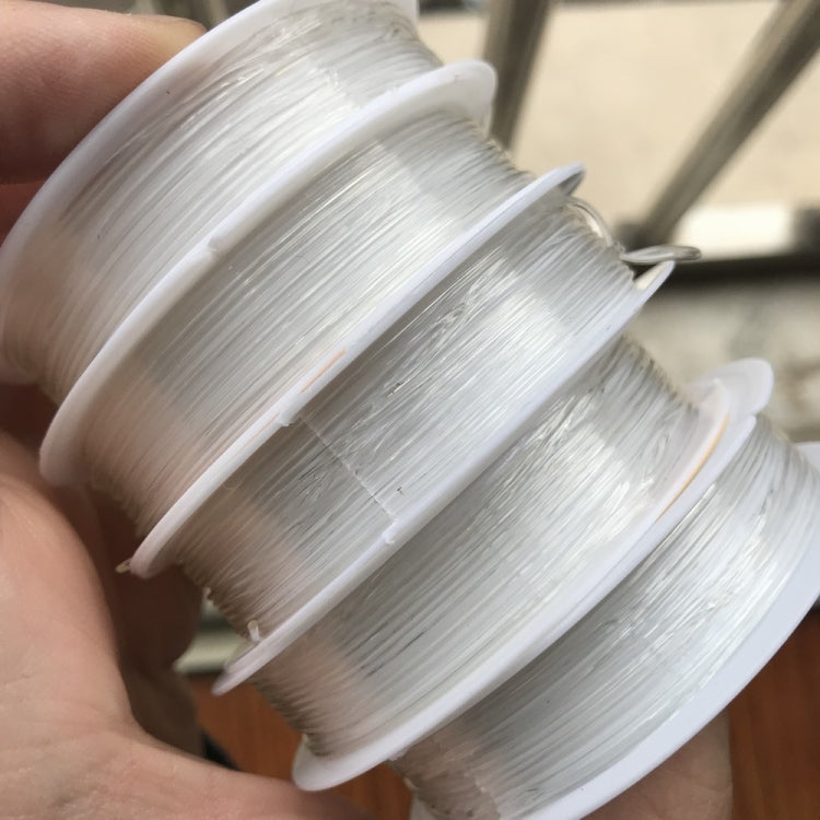 Handheld stack of transparent fishing line spools for DIY beading