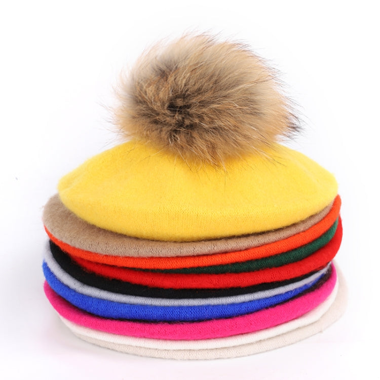 Colorful plush pom-pom beanies stacked in yellow, red, green, blue, and pink
