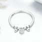 Sterling silver ring with a central heart CZ and two bow-like heart charms