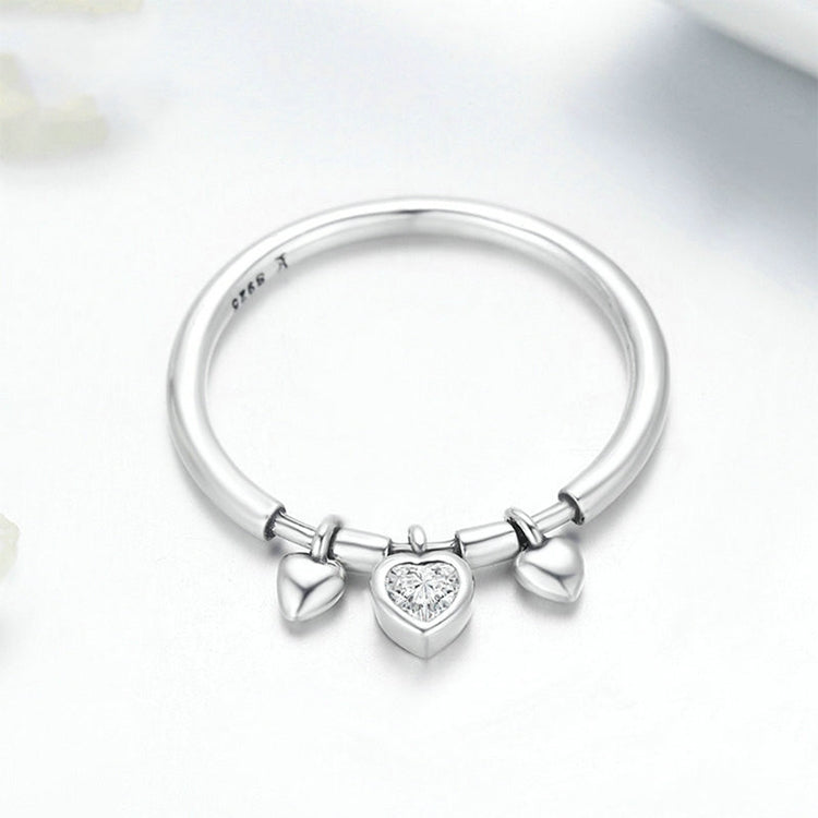 Sterling silver ring with a central heart CZ and two bow-like heart charms