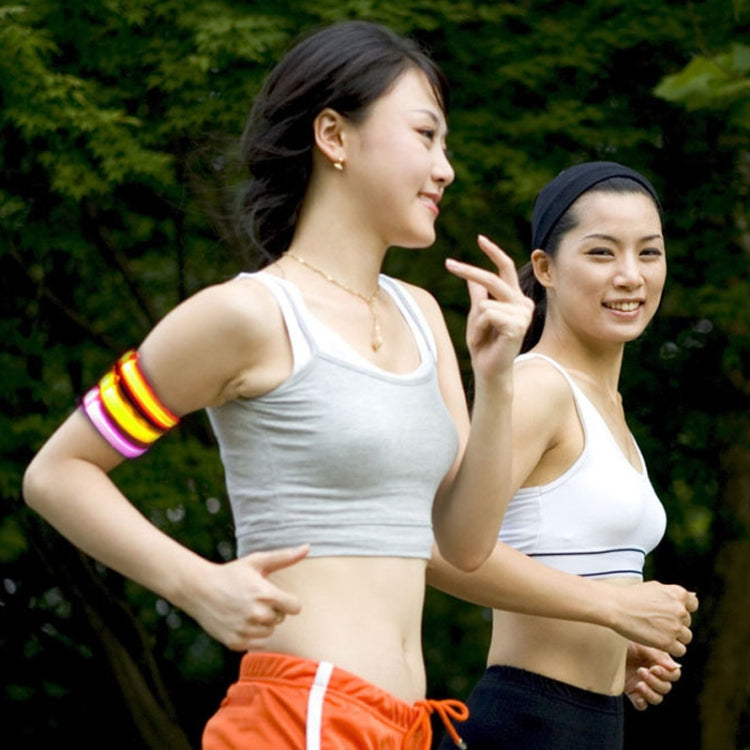 Multicolor glowing LED light armband bracelet worn on an arm over a white tank top