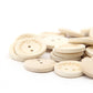 Pile of round natural wooden buttons with two-hole design and 'Handmade' text