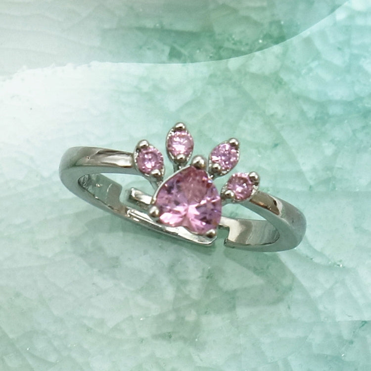 Pink crystal cat-claw ring with open silver-tone band, prong-set stones