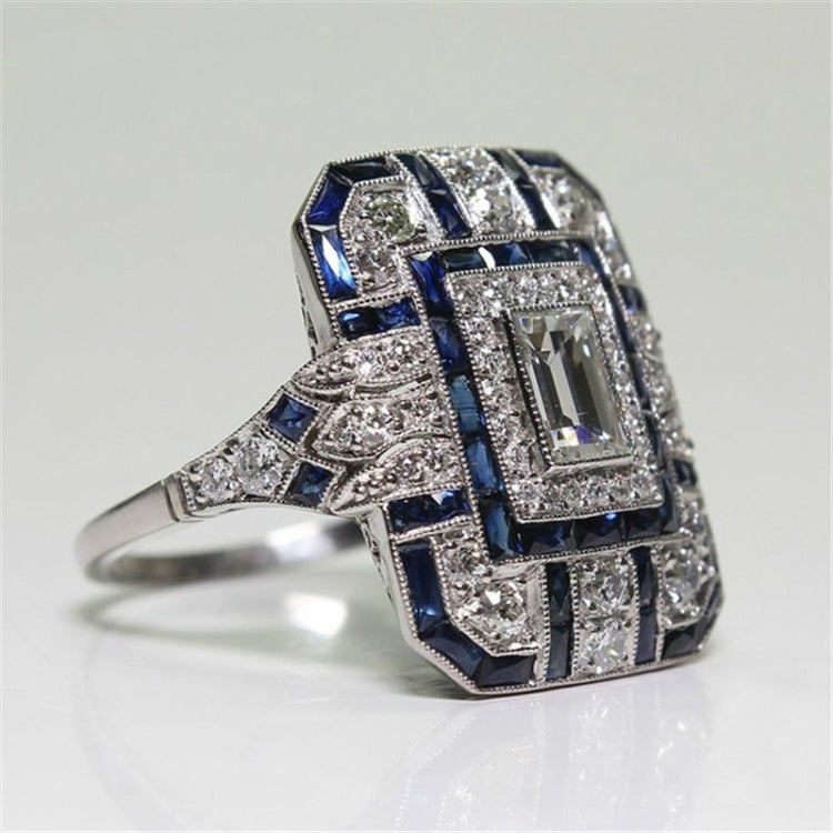Square-cut crystal halo engagement ring, side view with dark blue accent stones